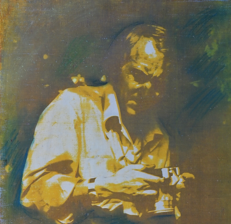 Zdjęcie przedstawia mężczyznę nachylonego nad aparatem fotograficznym.