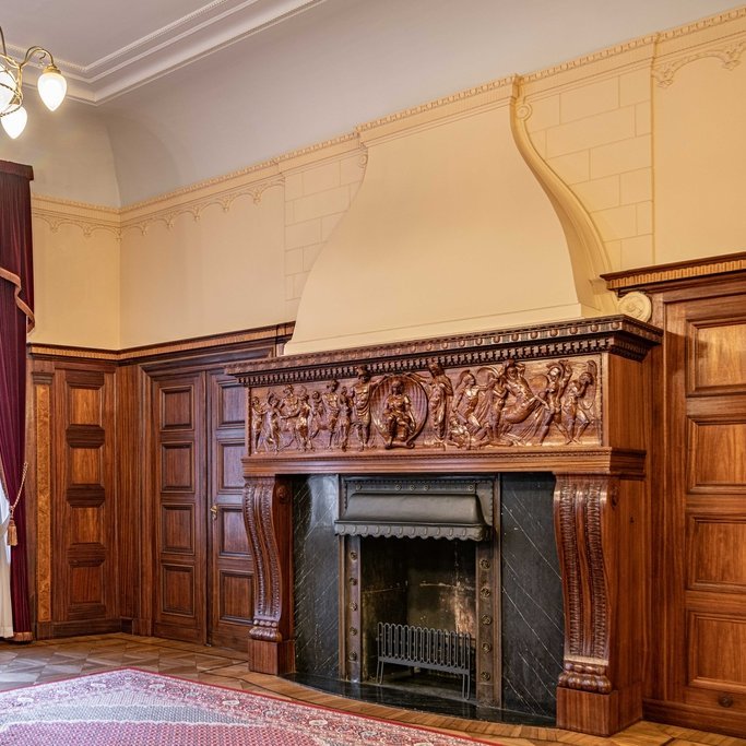 Fragment salonu wraz z znajdującym się w nim zabytkowym kominkiem