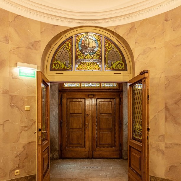 Drzwi prowadzące do hallu ze znajdującym się nad nimi witrażem